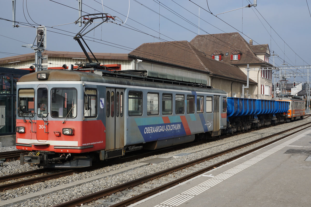 ASm/SNB:  Der ehemalige SNB Triebwagen Be 4/4 86 „WIEDLISBACH“ mit neuen Wappen der Einwohnergemeinde Wiedlisbach im Seeland unterwegs.
Die SNB Nummer 86 ergänzte die damalige Fahrzeugflotte derselben Baureihe aus dem Jahre 1966 erst im Jahre 1979. Mit Ansprachen des  Bahndirektors, Herr Dr. Ulrich Sinzig und dem damaligen Gemeindepräsidenten von Wiedlisbach, mit einer grossen Anteilnahme der Dorfbevölkerung sowie zu rassigen Märschen der Musikgesellschaft Wiedlisbach wurde der neuste SNB-Triebwagen  im Jahre 1979 in Wiedlisbach  feierlich auf den Namen  des historischen Städtchens Wiedlisbach getauft.  Da auch ein getauftes Triebfahrzeug während seinem ganzen Leben seinen Namen  behalten soll, hat der Bahnfreund Andreas Bögli aus Bannwil bereits zum zweiten  Mal die Erneuerung dieses Wappens für den ASm Be 4/4 304 (ehemals SNB Be 4/4 86) gespendet.  Da nach der  Inbetriebnahme der Be 4/8  110 bis 115 „STAR“ dieses Fahrzeug  vom Depot Langenthal zum Depot Täuffelen verschoben wurde,  wirbt er  nun im Seeland für Wiedlisbach.
Im Seeland wird dieser Triebwagen mit dem neuen Wappenschmuck  hoffentlich  noch viele Jahre vor schweren Kieszügen zwischen Siselen und Sutz  im Einsatz stehen.
Der Gönner, Herr Andreas Bögli, arbeitete mehrere Jahre bei der SNB als Lokführer.  Ihm gehört an dieser Stelle ein grosses Dankeschön für diese Spenden.  Es ist nicht selbstverständlich, dass sich eine Privatperson, die nicht einmal in Wiedlisbach wohnhaft ist,  für den Erhalt dieser Wappen engagiert hat.
Am 6. Februar 2018 wartete der Kieszug mit den Triebwagen Be 4/4 302 und Be 4/4 304 in Täuffelen auf Gleis 2 die Weiterfahrt nach Sutz ab. 
Foto: Walter Ruetsch  
