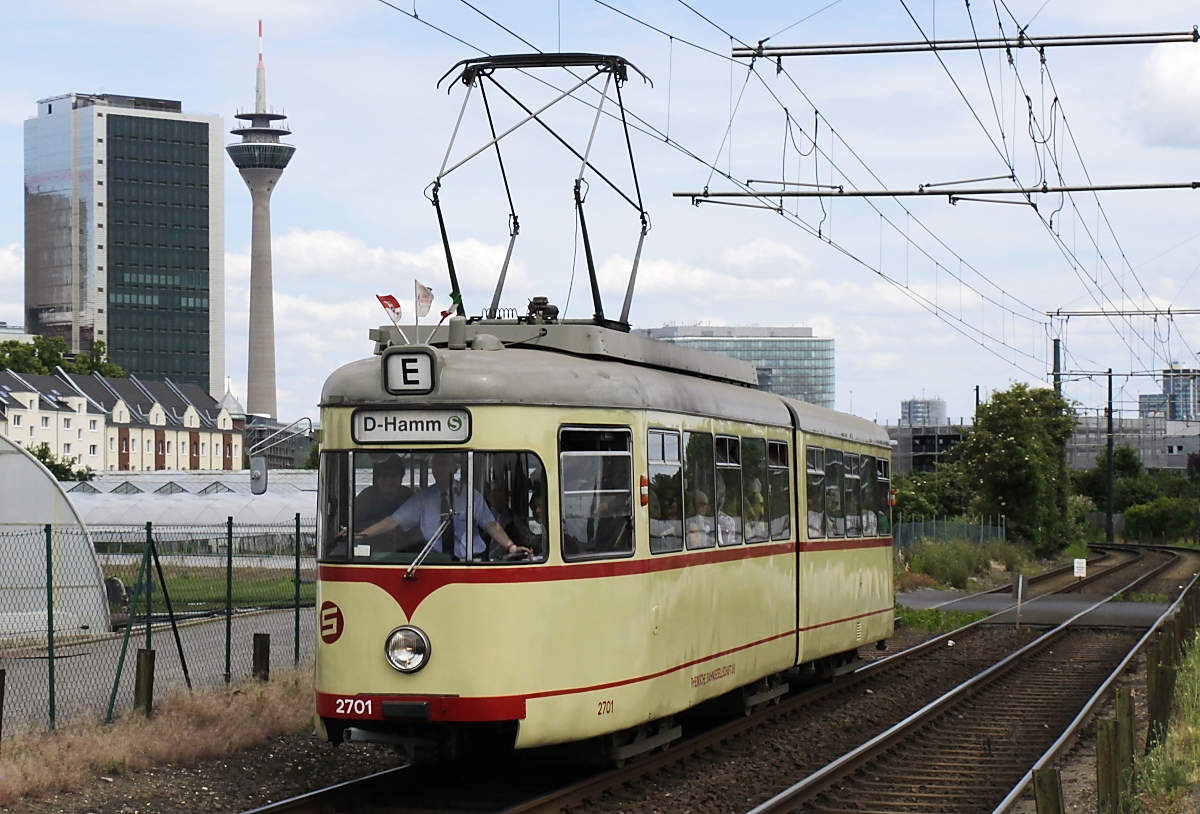 Auch der ex-Neusser GT6 2701 war am 09.06.2019 als Zubringer vom Hauptbahnhof eingesetzt, hier fährt er durch die landwirtschaftlich genutzten Flächen von Düsseldorf-Hamm. Nach der Stilllegung der Neusser Straßenbahn 1971 erwarb die Rheinbahn den Zweirichtungstriebwagen und baute ihn zu einem Einrichtungsfahrzeug um. Äußerlich ähnelten die 3 nach Neuss gelieferten Fahrzeuge den Meterspurwagen z. B. in Bochum/Gelsenkirchen und Heidelberg, es sind aber die einzigen für Normalspur gebauten Triebwagen dieser Bauart.