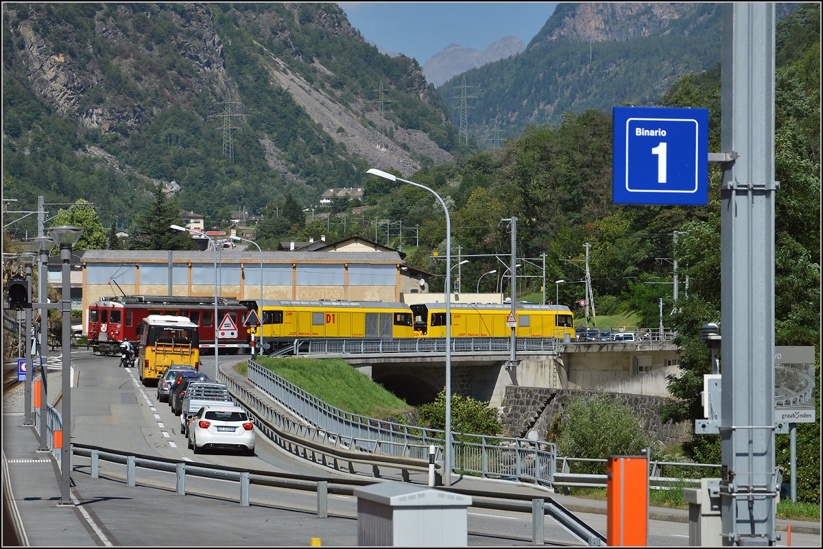 Auch hier müssen sich Eisenbahn und Automobile den Verkehrsraum teilen. Gemeinsam benutzte Brücke in Campocologno mit wartenden Autos und zwei neuen Dieselloks der RhB, sowie schiebend ein Motrice quaranta, Berninatriebwagen ABe 4/4 <sup>II</sup> 47 aus den 70ern. August 2015.