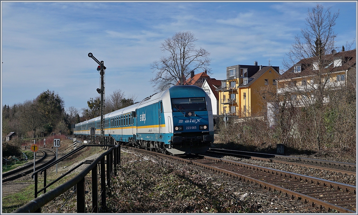 Auch Lindau Aeschbach bzw. die Abzweigung Lindau Aschbach lenkt den Lauf der Züge noch mit Formsignalen. Wahrend die Regionalbahn Züge der Bodenseegürtellinien in Lindau Aeschbach halten, scheint der über die Treppe links im Bild zugängliche  Bahnsteig  der Strecke ins Allgäu nur noch von Bahnfotografen und der Vegetation genutzt zu werden.
 
Im Bild die 223 065 mit einem Ales von München nach Lindau, die in Lindau Aeschach frei Einfahrt hat. 

16. März 2019