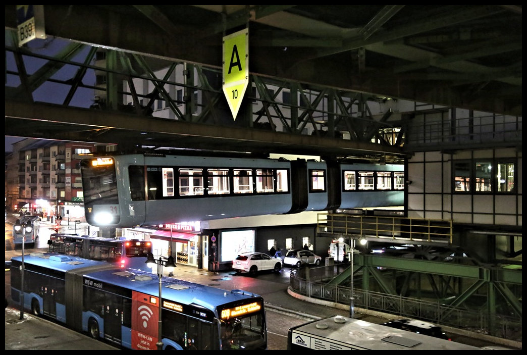 Auch nachts ist Wuppertal Oberbarmen ein reger Nahverkehrsknoten. Oben fährt die Schwebebahn, hier am 19.01.2023, gerade nach Wuppertal Vohwinkel ab. Darunter fahren die Busse des Stadtverkehrs. Und in unmittelbarer Nähe verkehren die Nahverkehrszüge der DB und der privaten Gesellschaften.