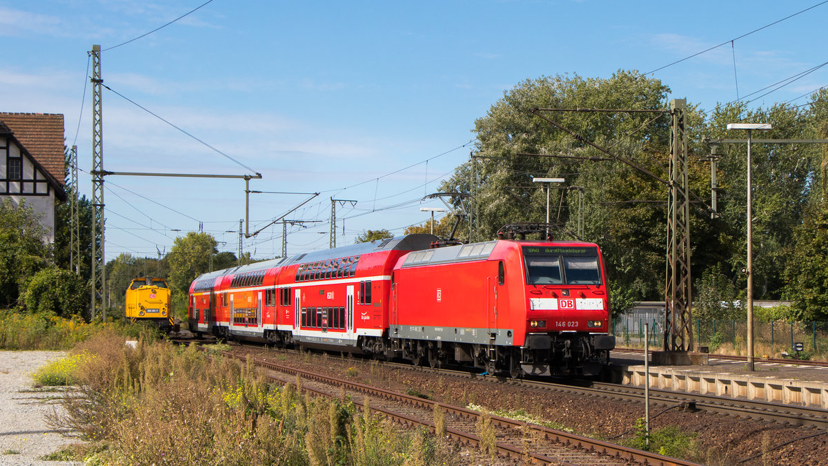 Auch der Regionalverkehr soll nicht zu kurz kommen. Am 9. September 2018 war 146 023-7 in Magdeburg-Sudenburg unterwegs. Eine Bahnbau V100 (Ost - 203 301-7), glänzt im Rot der Waggons. 