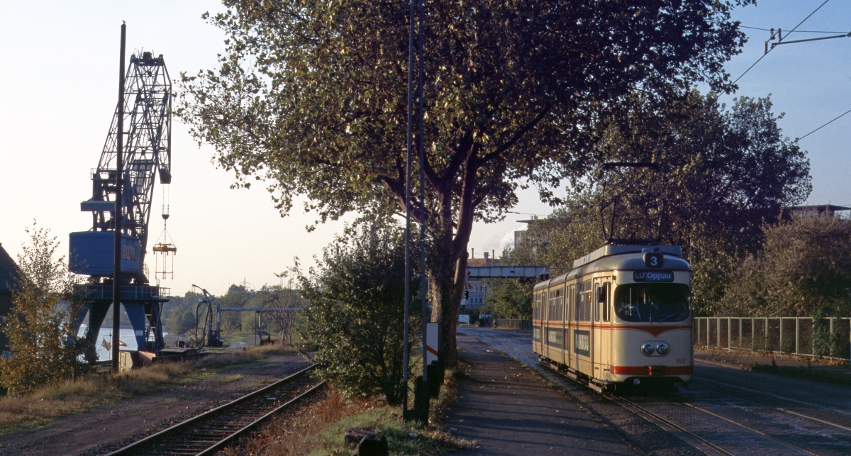 Auch in Straßenbahnnetzen finden sich bisweilen reizvolle Motive, wie hier in der Sandhofer Strasse in Mannheim mit einem Kran des Bonadieshafens am Altrhein. Aufnahme von TW 153 der VBL am 23.7.1995. 