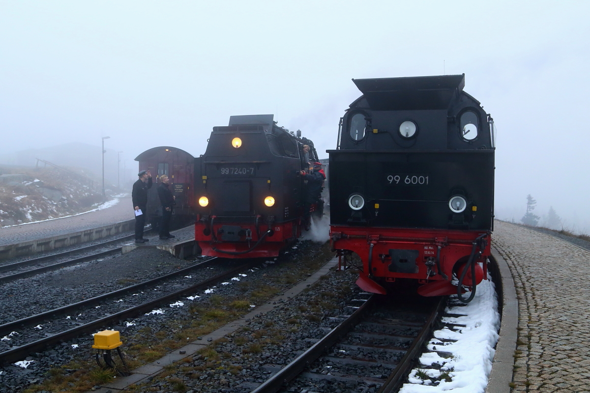 Auch wenn das Wetter sich am späten Nachmittag des 16.10.2015 von seiner  Brocken-typischen  Seite zeigt, herrscht nichtsdestoweniger reger Betrieb im Brockenbahnhof. Während rechts 99 6001 mit ihrem IG HSB-Sonderzug vor der Rückfahrt nach Wernigerode eine längere Pause einlegt, setzt 99 7240 ans andere Ende ihres Planzuges um und startet mit ihm wenig später als P 8936 in Richtung Wernigerode. Diese Fahrt wird jedoch bereits in Drei Annen Hohne enden, da die Lok wegen eines Maschinenschadens, diese dort nicht mehr fortsetzen kann!