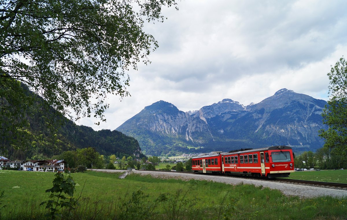 Auch die Züge der Zillertalbahn verkehren momentan in verkürzter Zusammenstellung. Am 03.05.2020 ist eine solche aus einem Steuerwagen und einem VT bestehende Kurzzugeinheit bei Schlitters als R 148 auf dem Weg Richtung Jenbach. Im Hintergrund steht das mächtige Rofan.