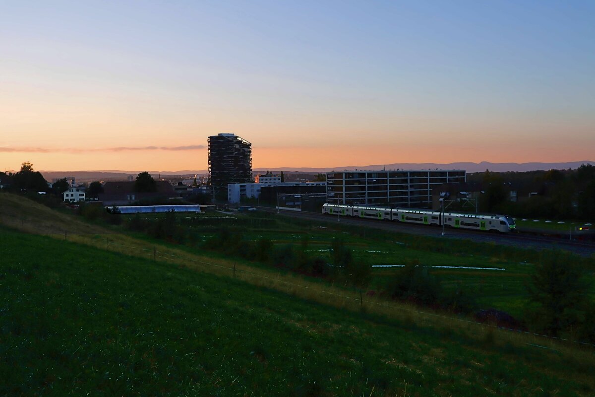 Auf der Berner S3 fährt ein Doppelstockzug  Mutz  durch Wabern Richtung Belp, mit Blick auf Bern. Der Wetterdienst informiert, dass die roten Himmel durch feinste Aschepartikelchen entstehen, die von den grossen Waldbränden in Kalifornien her stammen. 3.August 2022  