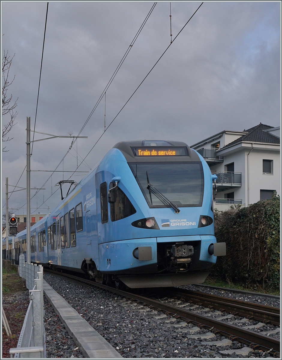 Auf dem gut siebenhundert Meer langen Dreischienen Gleis fährt der TPF Flirt RABe 527 192  Grisoni  als Dienstzug in Richtung Bulle. 

22. Dezember 2022