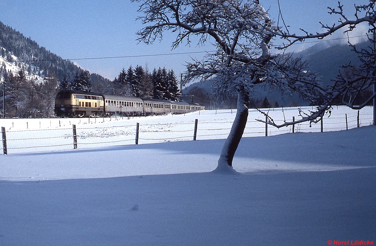 Auf dem Weg von Bayrischzell nach München hat eine 218 gerade den Bahnhof Fischhausen-Neuhaus verlassen (Januar 1986)