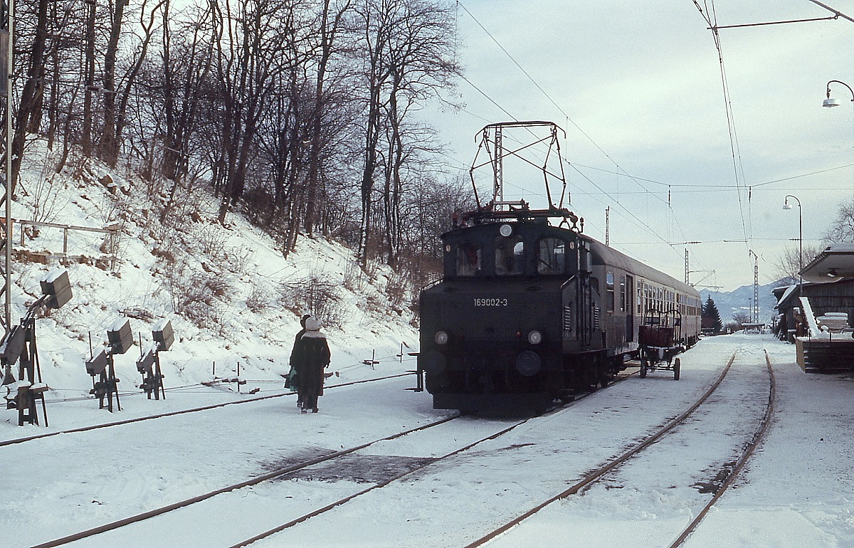 Auf dem Weg von Murnau nach Oberammergau macht 169 002-3 im Januar 1979 einen Zwischenhalt im Bahnhof Bad Kohlgrub. Wie man am Gepäckkarren vor dem Traglastenabteil sieht, war damals die Gepäckbeförderung mit dem Zug noch selbstverständlich.