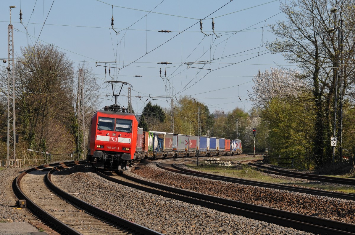 Auf dem Weg nach Aachen-West durchfährt 145 035-2 mit einem LKW-Zug den Gleisbogen vor dem Hbf. Eschweiler. Das Bild entstand am 18/04/2015 vom Bahnsteig aus.