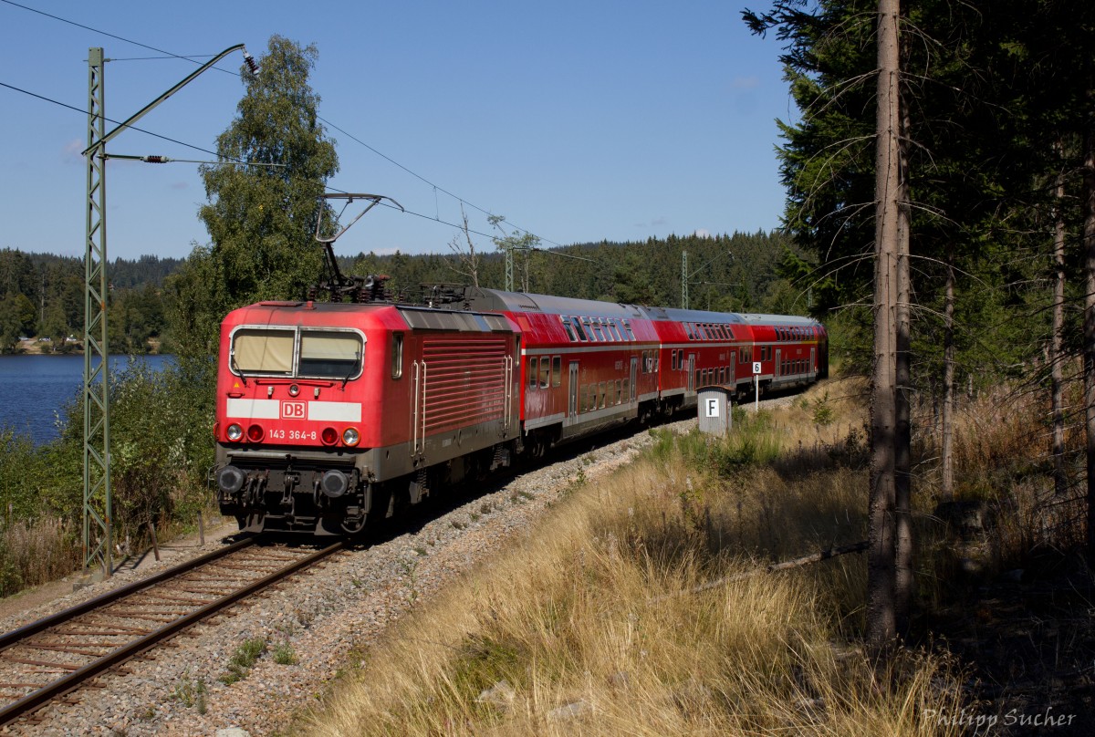 Auf dem Weg nach Titisee kommt die 143 364 mit RB26940 am Windgfällweiher vorbei. Zusammen mit dem Schluchsee und dem Titisee ist der Windgfällweiher namensgebend für die Dreiseenbahn (KBS 728). Aufgenommen am 10.09.2015
