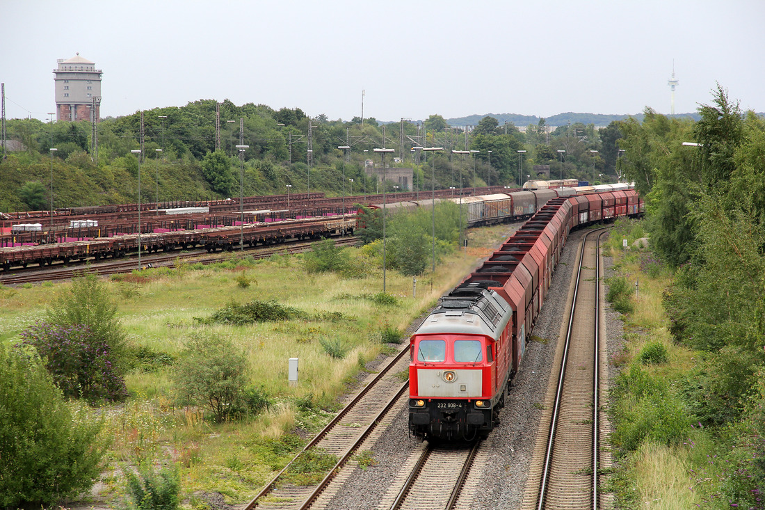 Auf dem Weg zum Hüttenwerk Krupp Mannesmann (HKM) durchfährt 232 908 mit ihrem beeindruckenden Ganzzug auch den Güterbahnhof Duisburg-Hochfeld Süd.
Das Foto entstand am 8. August 2017.