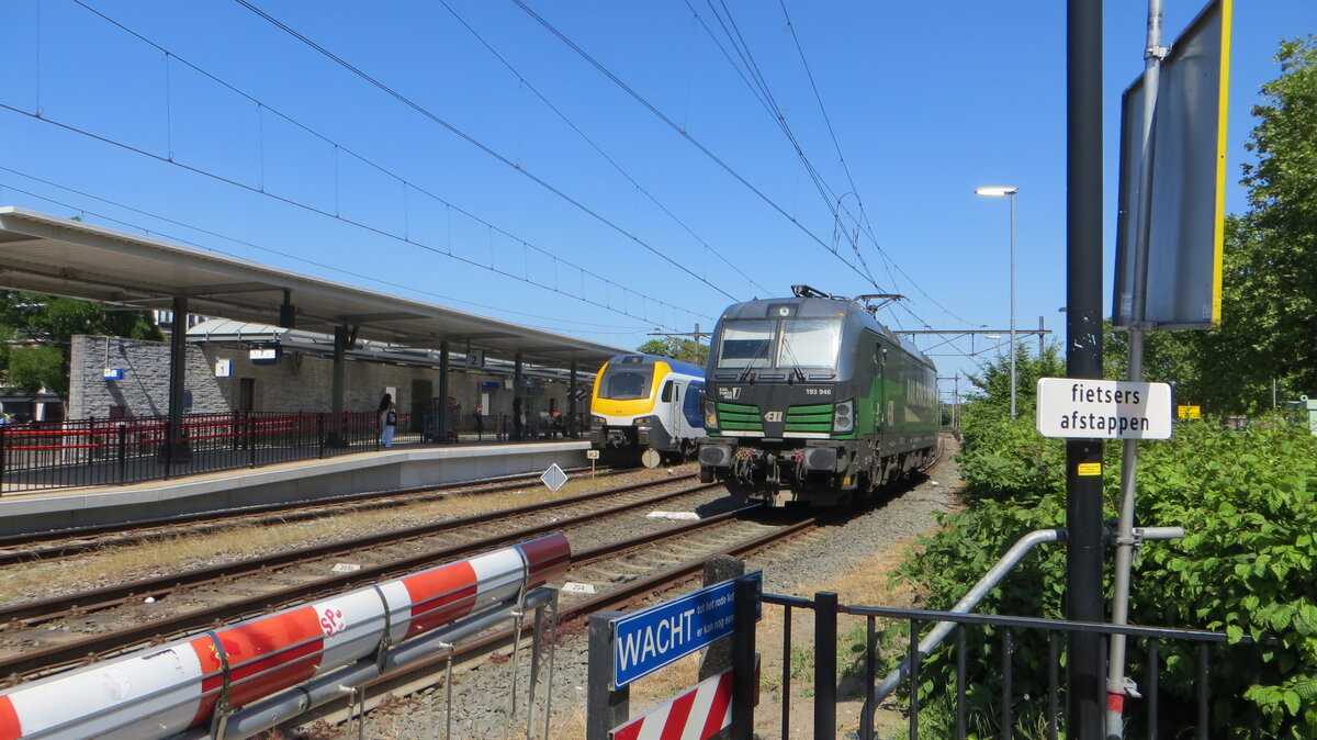 Auf diesem Foto ist eine Lokomotive vom Typ Siemens Vectron MS zu sehen – betrieben von Rail Force One und von ELL geleast Nummer 193 946 –, die im Bahnhof Oss ein Rangier man�ver durchf�hrt. Sie steht neben einem wartenden Zug des Typs Flirt 3 Nummer 2517, der f�r die Abfahrt in Richtung Dordrecht bereitsteht. Die Aufnahme entstand kurz nach Abschluss von Bauarbeiten im Bahnhof Oss, bei denen die Bahnsteige auf das Niveau der Zugb�den angehoben wurden. Der Gleisabschnitt in Richtung Nijmegen blieb aufgrund noch andauernder Arbeiten f�r den Zugverkehr gesperrt. Die Vectron befindet sich vermutlich dort, um die Nacht zu verbringen oder auf einen G�terzug zu warten, der vom OOC (Osse Overslag Centrale) eintrifft.
Aufnahmedatum: 26.05.2026