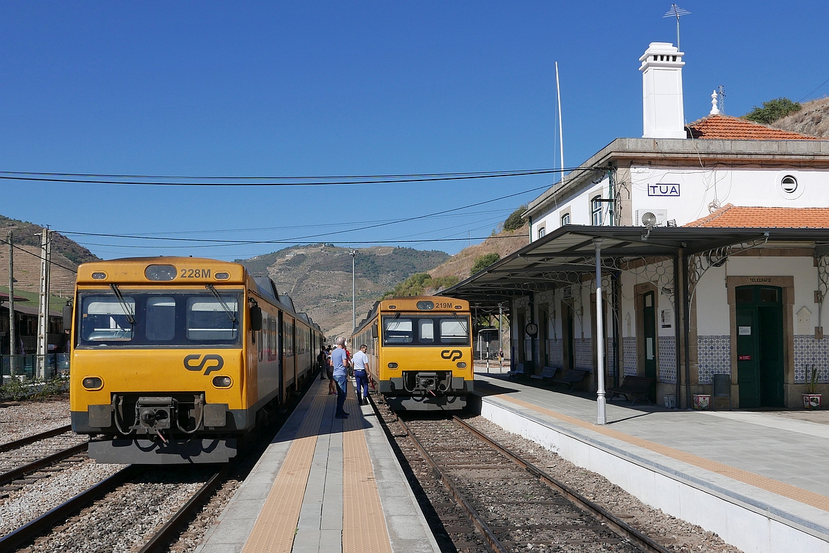 Auf der im Douro-Tal einspurigen Linha do Douro kreuzen sich Triebwagen 228M von Porto São Bento nach Pocinho und der Gegenzug mit Triebwagen 219M im Bahnhof von Tua (03.10.2017).