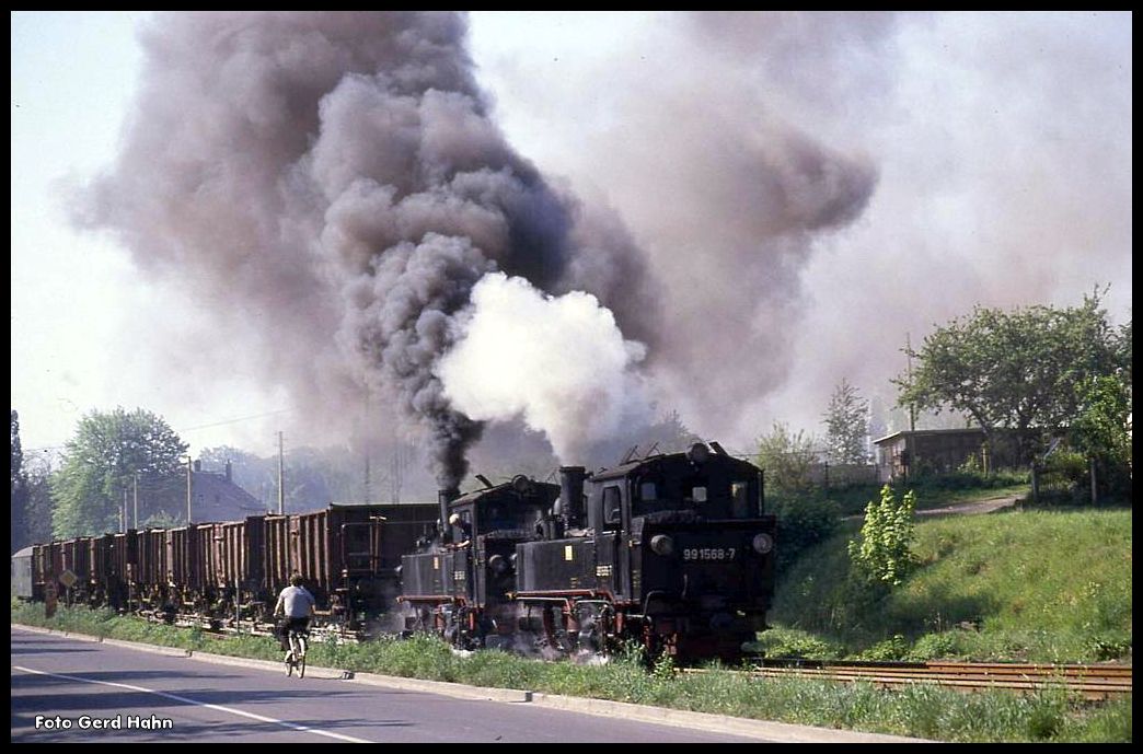 Auf eines konnte man sich bei den Oschatzer Loks immer verlassen: Für mächtig Qualm war immer gesorgt! Hier hat am 3.5.1990 die 991568 der 991564 vorgespannt, um gemeinsam einen schweren Kaolin Zug über die letzte Steigung in den Schmalspurbahnhof in Oschatz zu schleppen.