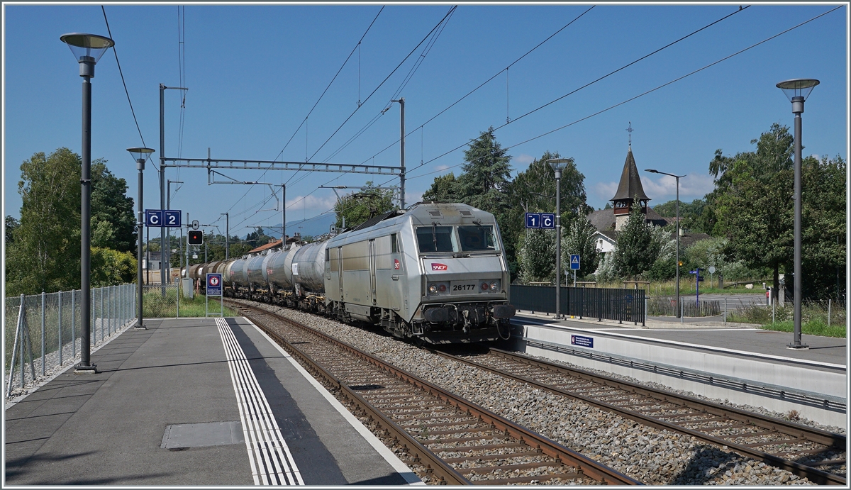 Auf den ersten Blick eine typisch, zeitgemässe SBB Station, nur der Zug scheint nicht zu passen... 
Die SNCF BB 26177 (Sybic) fährt mit einem gemischten Güterzug auf dem Weg nach Genève La Praille durch den Bahnhof von Satigny, auf der Strecke (Bellegarde Ain) - La Plaine - Genève, die abweichend vom übrigen SBB Netz mit 25 000 Volt 50 Hertz Wechselstrom elektrifiziert ist. 

19. Juli 2021