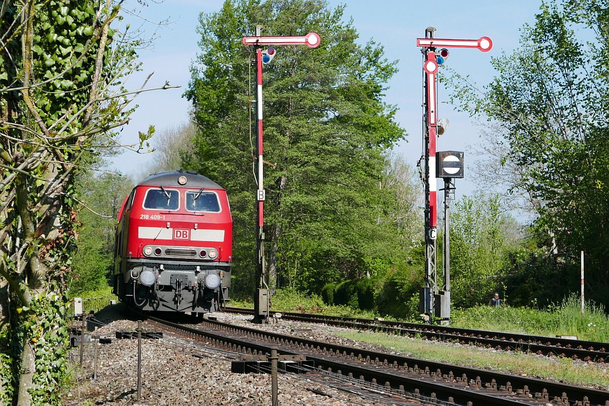 Auf der Fahrt von Aulendorf nach Lindau zieht 218 409-1 am 02.05.2019 die Wagen des RE 3227 an den Ausfahrsignalen des Bahnhofs von Enzisweiler vorbei.