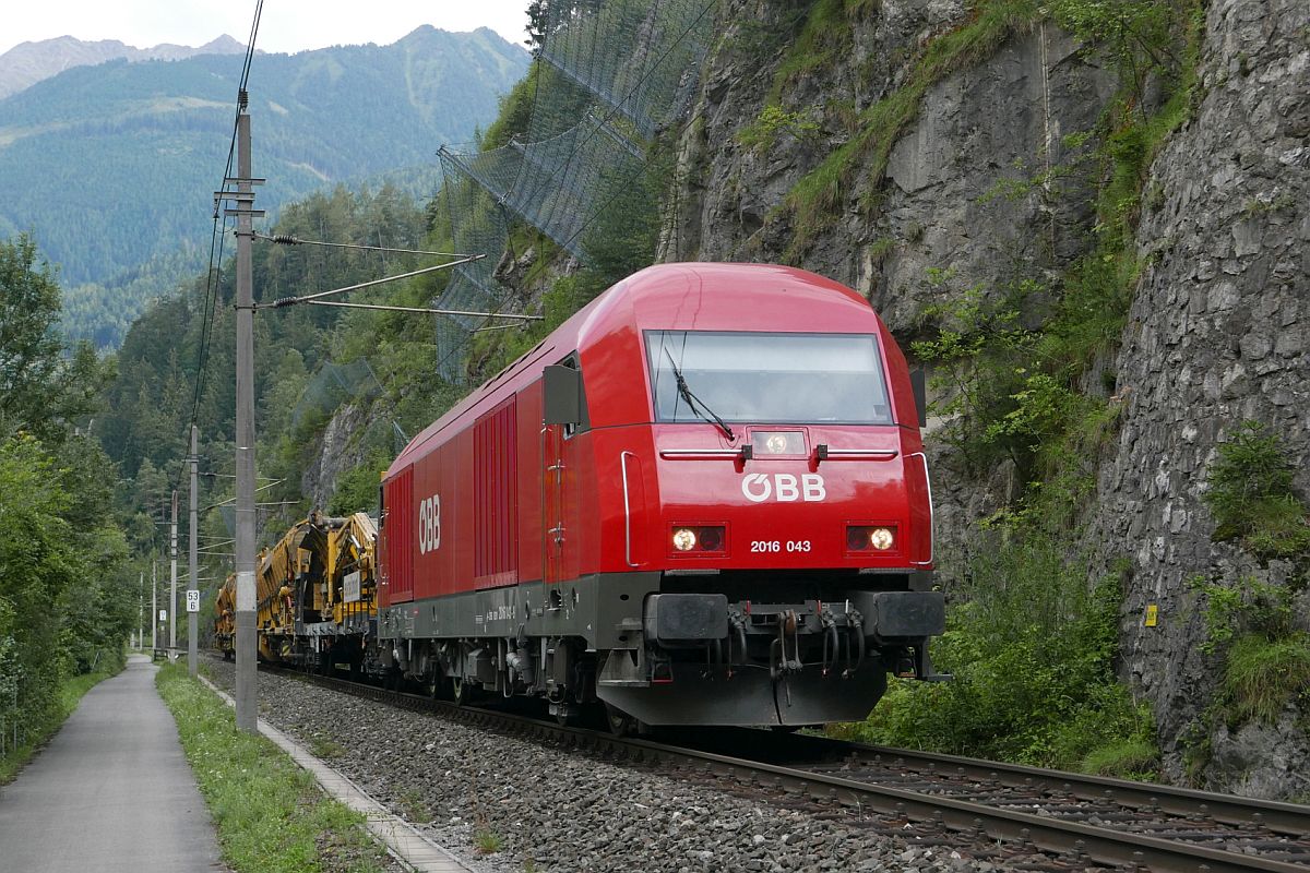 Auf der Fahrt nach Roppen zum Gleisbauzug schiebt 2016 043 die in Imst-Pitztal entleerten Materialförder- und Siloeinheiten am 18.08.2018 durch das tief eingeschnittene Inntal zwischen diesen beiden Bahnhöfen.