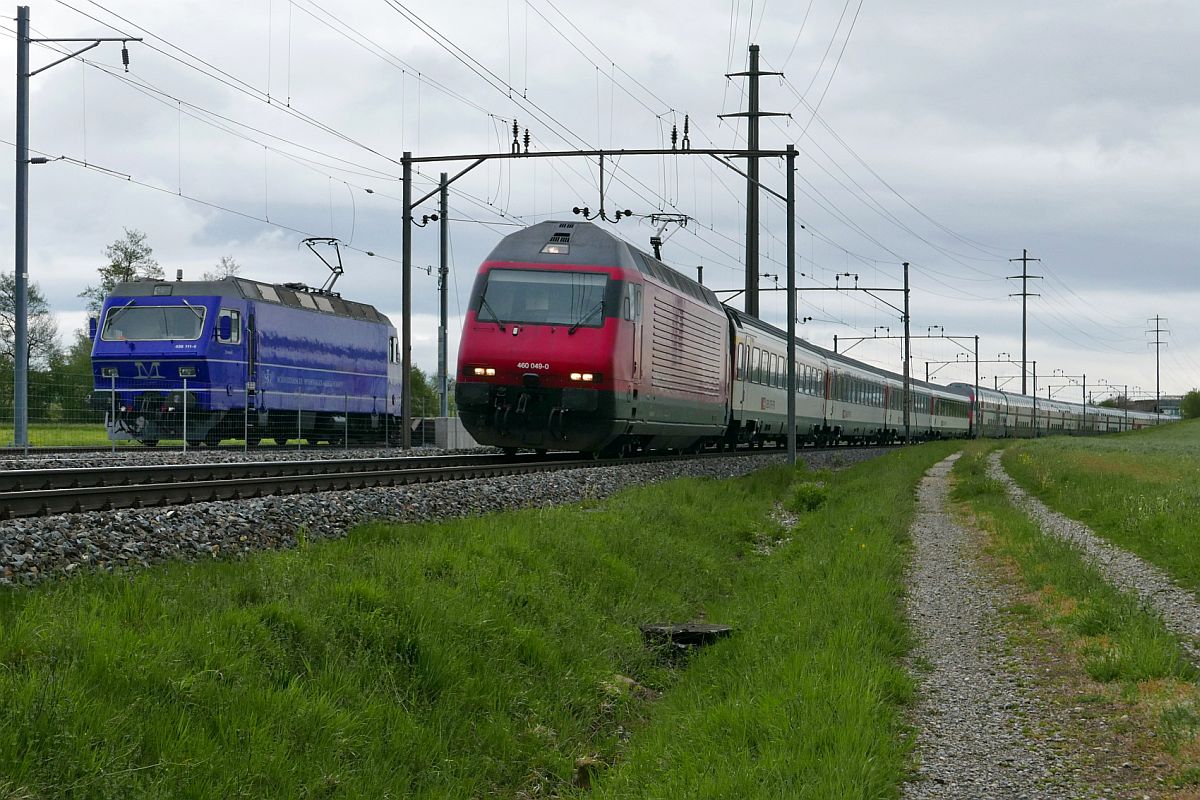 Auf der Fahrt von Romanshorn nach Brig fhrt Re 460 049-9 am 03.05.2019 mit den Wagen des IC 826 an der auf dem Auszieh-/Stumpengleis des Stadler-Werkes in Erlen abgestellten Re 456 111-4 der M-Rail AG vorbei.