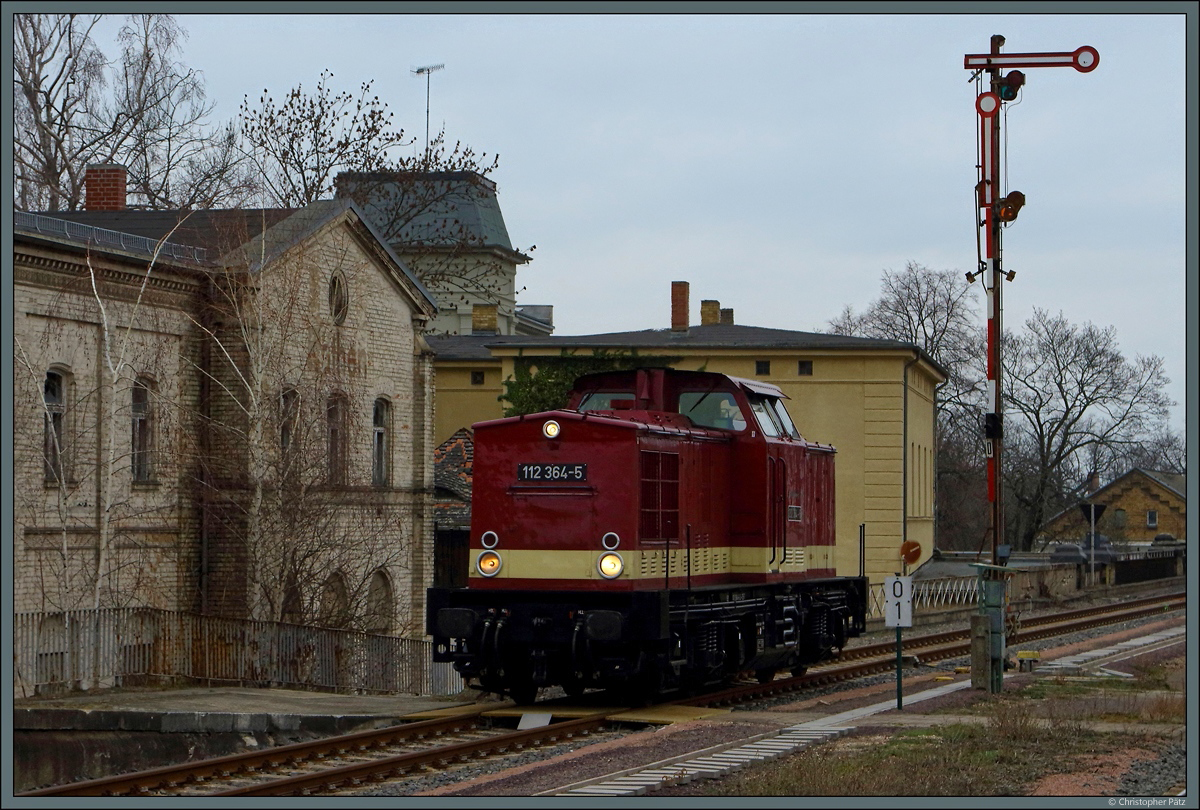 Auf Gleis 1 rollt 112 364-5 am Ausfahrsignal D und dem 1870/71 eröffneten alten Empfangsgebäude von Köthen vorbei. (02.03.2019)