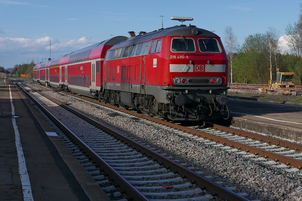Auf Gleis 2 schiebt 218 496-8 den IRE 4236, Lindau - Stuttgart, aus dem Bahnhof von Aulendorf während im Gleisbett von Gleis 5 eine Planierraupe steht (12.04.2016).