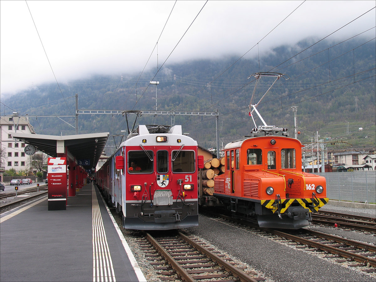 Auf Gleis 3 steht abfahrbereit R 1644 Berninabahn mit Abe 4/4 III Nr. 51  Poschiavo  + Nr. 53  Tirano  nach St. Moritz, daneben Ge 2/2 162 mit einem Zug Holz; Tirano RhB, 18.04.2008

