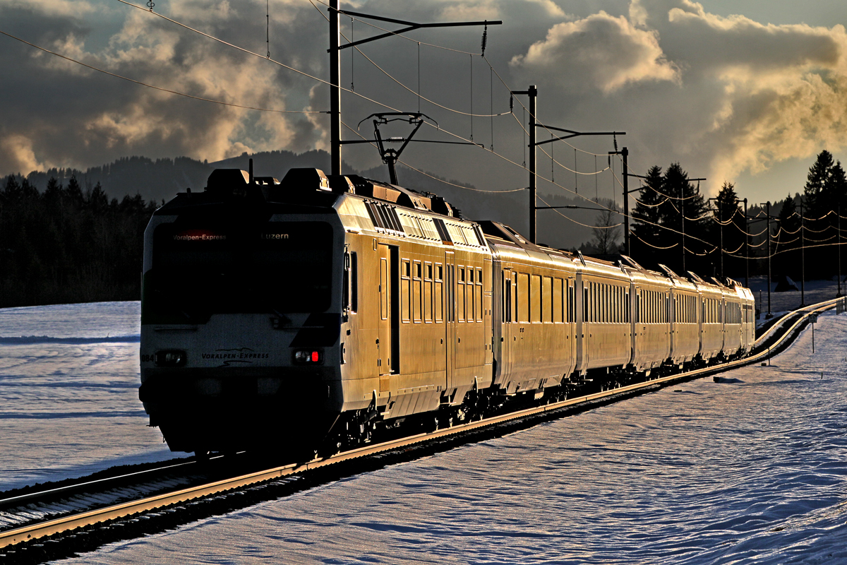 >Auf goldenen Schienen unterwegs<    Der SOB Triebzug RBDe 561 084 braust im allerletzten,goldenen Abendlicht dem Ziele Luzern entgegen.Bild Schwyzerbrugg vom 25.2.2015
