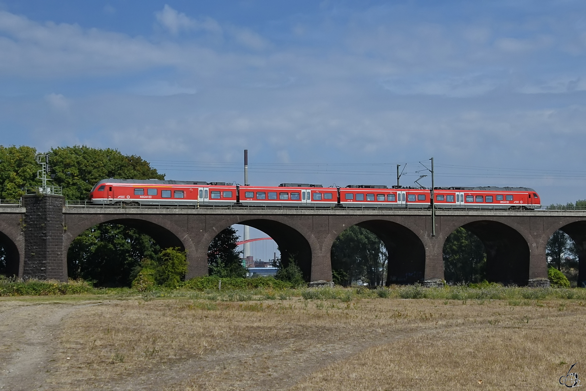 Auf der Hochfelder Eisenbahnbrücke ist gerade der DB-Triebzug 1428 010 unterwegs. (August 2022)