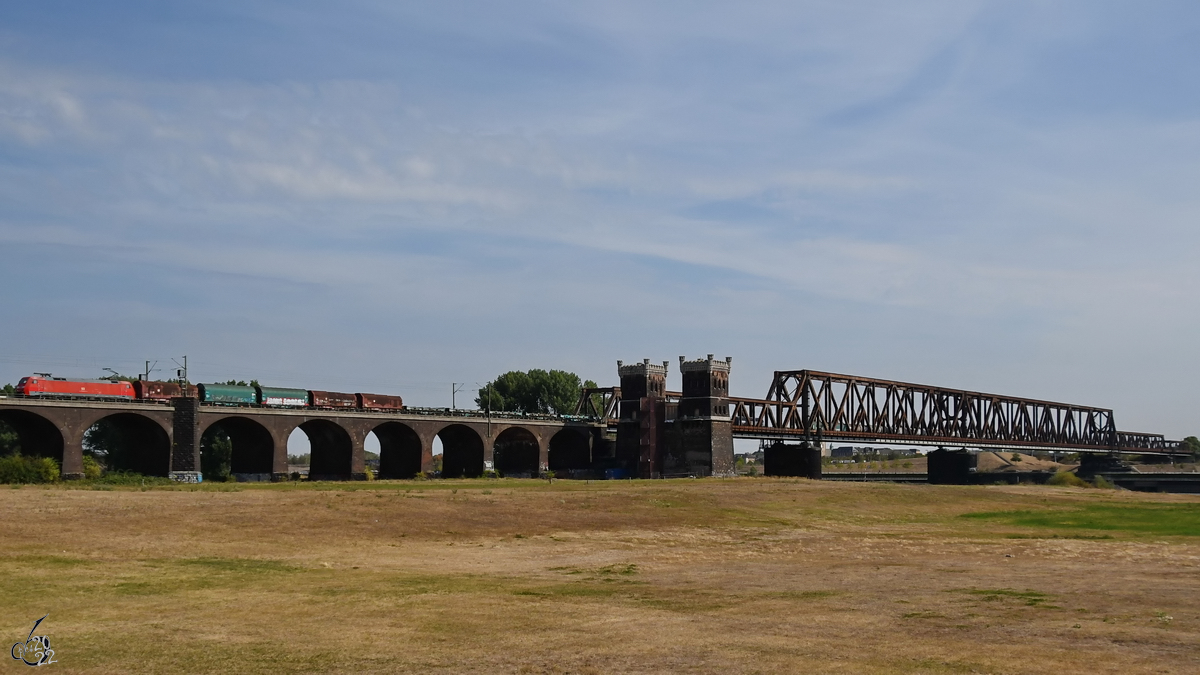Auf der Hochfelder Eisenbahnbrücke ist gerade die Elektrolokomotive 152 025-3 mit einem gemischten Güterzug unterwegs. (August 2022)