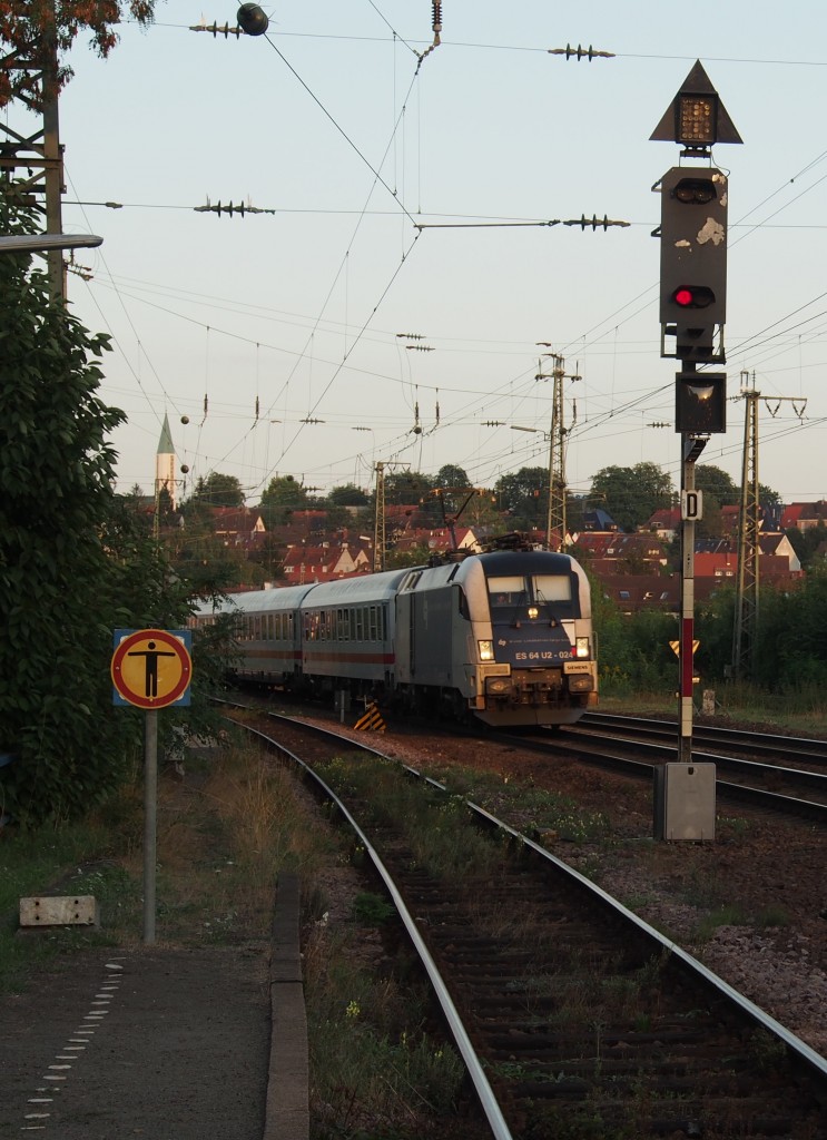 Auf Höhe des nur noch vereinzelt angefahrenen HP  Kaiserslautern Pfaffwerk  fährt Dispo-Taurus ES 64 U2-024 (als 182 524-9 in Diensten der DB Fernverkehr, hier noch im KLeider der WLB) mit IC 2052 im letzten Streiflicht pünktlich von Kaiserslautern aus weiter nach Saarbrücken. Links am HP selbst die Strecke nach Lauterecken-Grumbach, in der Mitte die Hauptgleise der  Pfälzischen Ludwigsbahn  und rechts der Hauptstrecke führen Gleise nach Pirmasens. 
Kaiserslautern, der 31.08.2015