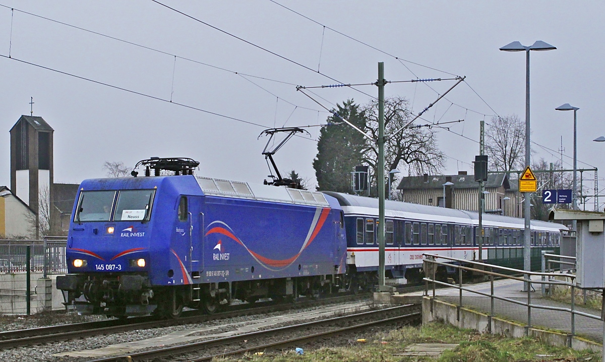 Auf ihrer Fahrt von Krefeld nach Neuss verlässt die 145 087-3 von SRI am 12.01.2024 den Bahnhof Meerbusch-Osterrath