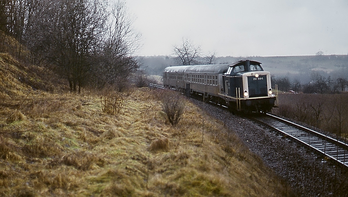 Auf der inzwischen elektrifizierten Bahnstrecke von Marbach nach Backnang ist 212 349-5 Ende der 1980er Jahre mit einem Nahverkehrszug unterwegs