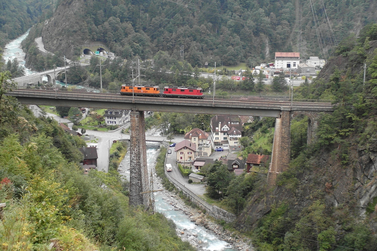 Auf der Kerstelenbachbrücke befinden sich eine SBB- und InterregioCargo-Re 4/4 II auf der Fahrt Richtung Erstfeld. Amsteg, 29.09.2015.