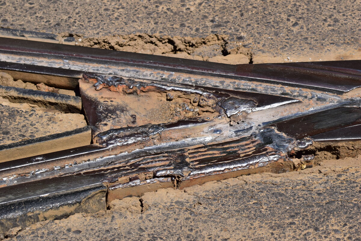 Auf der Kreuzung 11 lunie rumpelte es doch m�chtig beim �berfahren der Herzst�cke. W�hrend einer Rotphase habe ich mir das Herzst�ck mal genauer angesehen und konnte folgenenden Zustand festhalten. Es sieht so aus als h�tte man versucht das Herzst�ck provisorisch zu reparieren. Leider ist dieser Zustand an vielen Stellen im unmodernisierten Netz von Bukarest zu finden. 

Bukarest 02.08.2026