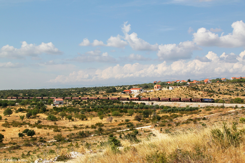 Auf der Strecke Knin – Zadar ist neben 3 Personenzugpaaren (gebildet aus BR 7122) auch hin und wieder (manchmal sogar mehrmals pro Woche) ein G�terzugpaar unterwegs. Am 27.08.2013 hatte 2062 111 die Aufgabe, den G�terzug nach Zadar und zur�ck zu bespannen und die unterwegs anfallenden Rangierarbeiten zu erledigen. Hier ist die R�ckfahrt des 61170 von Zadar nach Knin bei Nadine zu sehen. (27.08.2013)