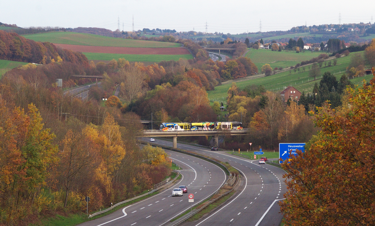 Auf der Suche nach neuen Motiven waren wir am 08.11.2015 im Heusweiler Ortsteil Hirtel unterwegs. Von der Feldwegbrücke über die Autobahn 8 hat man einen Blick auf die Köllertalbahn, heute die Trasse der Saarbahn zwischen Heusweiler und Lebach.
Mit ein paar Minuten Verspätung rollt ein Saarbahntriebwagen über die A8 in Richtung Heusweiler. Bahnstrecke 3291 Lebach - Völklingen. 