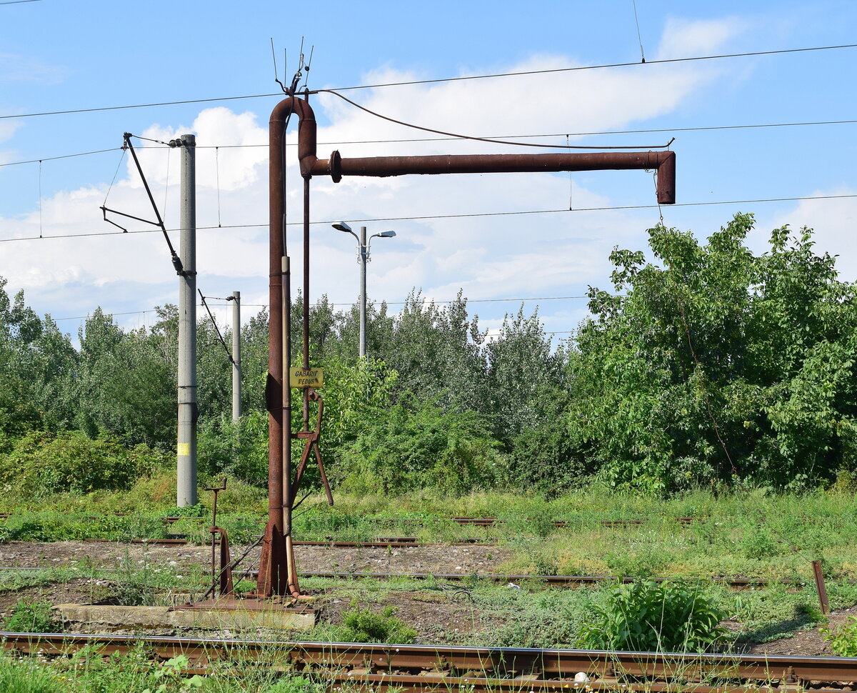 Auf vielen Bahnh�fen besonders au�erhalb der Hauptbahnen findet man heute noch Wasserkr�ne in verschiendensten Bauarten. Hier sieht man einen doch sehr schmalen Wasserkran in Ploiesti Nord.

Ploiesti Nord 27.07.2026