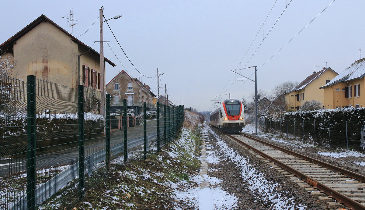 Auf der wiedereröffneten Strecke Delle - Belfort: Typische Dorfatmosphäre bei Grandvillars, mit SBB Zweifrequenzzug 522 206. Aufnahme hinter dem etwas niedrigeren Zaun beim Bahnübergang).  11.Januar 2019 