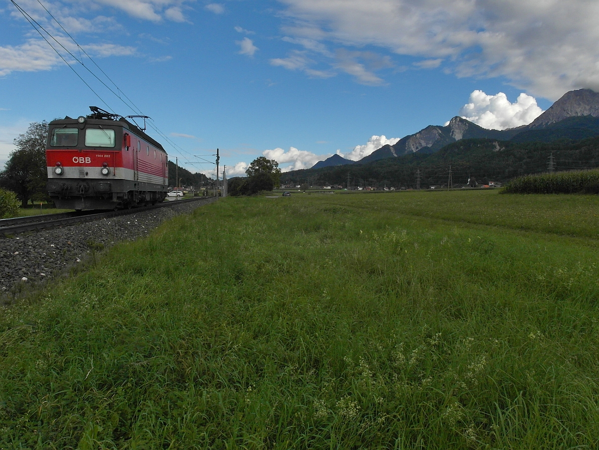 Auf der zwischen dem Faaker See und den Karawanken liegenden Bahnstrecke fährt 1144 282 am 15.09.2014 bei Faak am See in Richtung Villach. Am rechten Bildrand ist der 2.145 m hohe Mittagskogel, einer der markantesten Berge der Karawanken zu sehen.