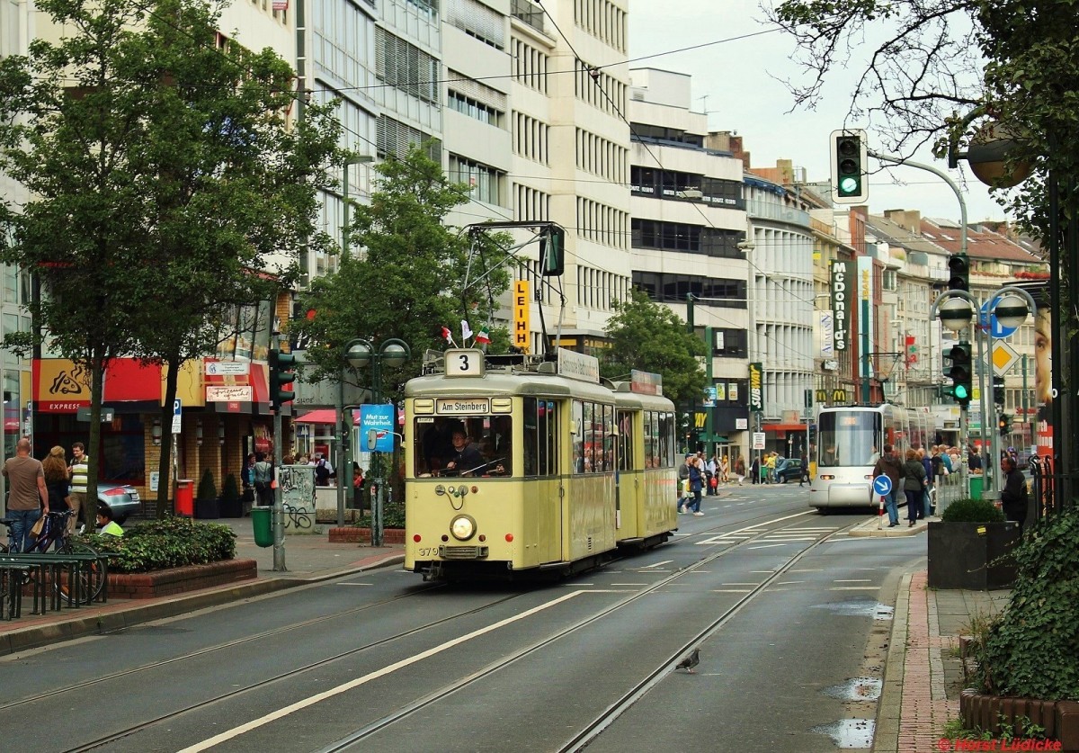 Aufbau-Tw 379 (Baujahr 1954) und Bw 643 auf der Schadowstraße in Düsseldorf am 08.09.2013. Der Zug war als kostenloser Zubringer zu den Feierlichkeiten im Rahmen des Bürgerfestes anläßlich der 725-jährigen Stadterhebung eingesetzt. Wenn die Ost-West-U-Bahn in etwa zwei Jahren ihren Betrieb aufnimmt, werden hier keine Straßenbahnen mehr verkehren.