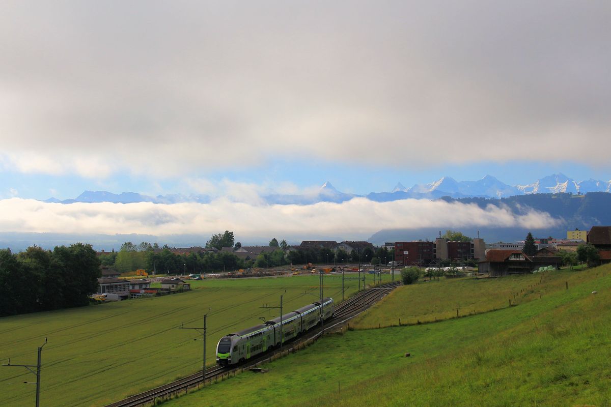 Aufhellung nach heftigem Regen, über den Berner Alpen ist der Himmel schon blau. Davor ein BLS-Triebzug  Mutz  Serie 515, 22.Juni 2016 