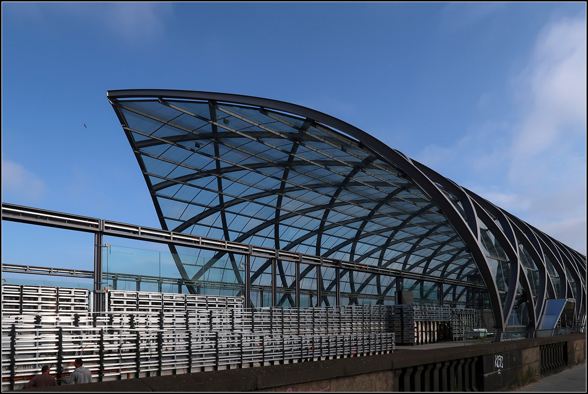 Aufwändige Konstruktion -

Blick von Süden auf die futuristische U4-Station Elbbrücken am östlichen Ende der Hamburger Hafencity. Von hier aus kann die U4 in Richtung Hamburg-Wilhelmsburg verlängert werden. Auch die nach schweren Kriegszerstörungen abgebrochene Hochbahnstrecke Hauptbahnhof - Rothenburgsort sollte weiter nach Süden verlängert werden. Diese hätte in der oberen Ebene der Freihafenbrücke fahren sollen, die dafür schon vorbereitet war. Die weitere Verlängerung der U4 würde hier ihre eigene Brücke bekommen.

15.08.2018 (M)