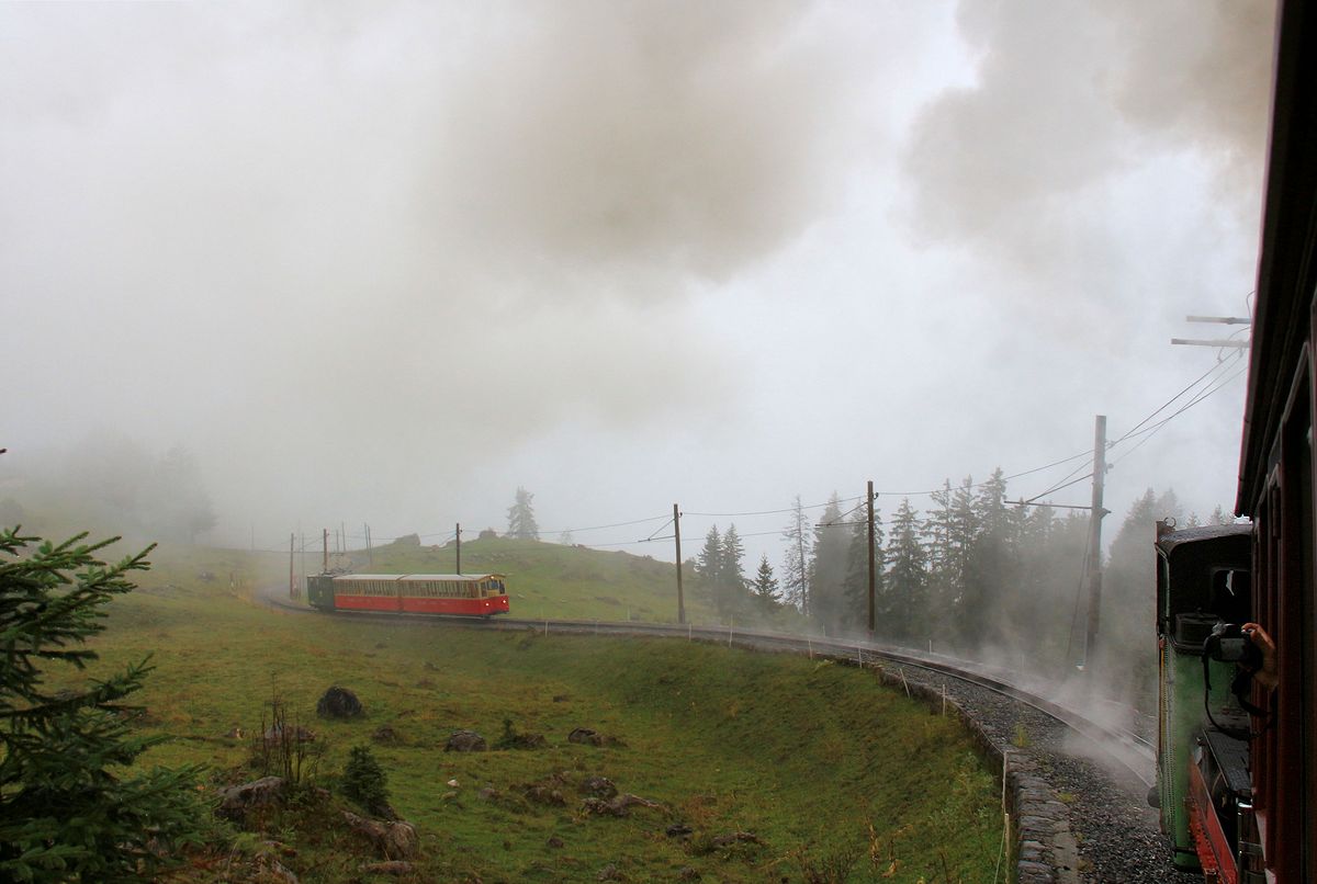 Aufwärts geht's mit dem Dampfzug der Schynigen Platte Bahn ob Breitlauenen durch die Wolken. Hinten folgt ein elektrischer Zug mit Lok 62. 2.September 2017 