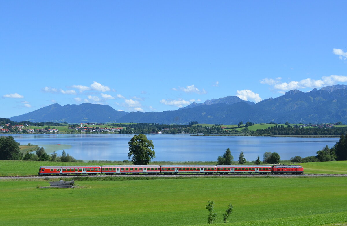 August 2014: 218 489 mit ihrer Regionalbahn nach Füssen vor dem Hopfensee bei Hopferau.