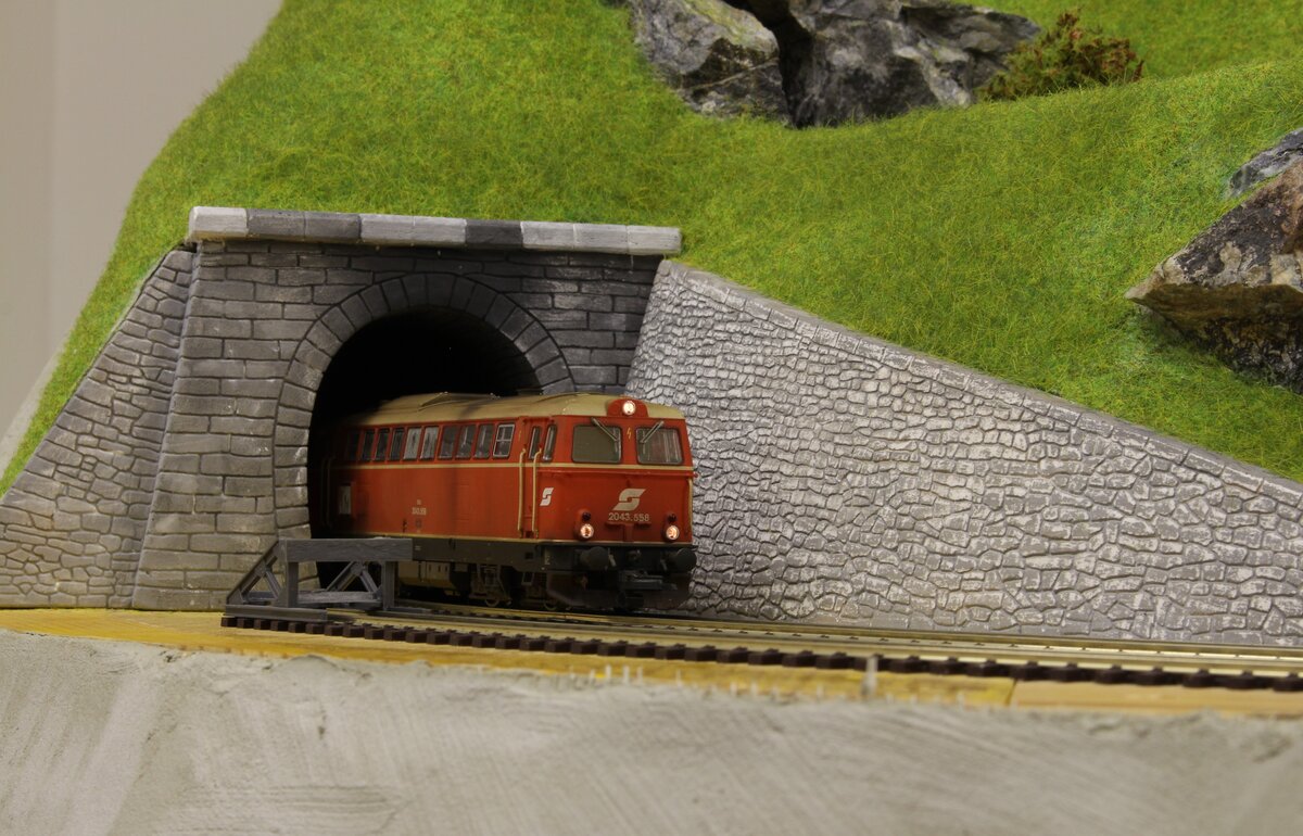 Aus dem 1394m langen Platentunnel kommen an einem heißen Sommertag 1988 die 2043.558 gemeinsam mit der 2043.555 als Lokzug vom Bahnhof Präbichl in den Bahnhof Erzberg um den zweiten beladenen Halbzug abzuholen.