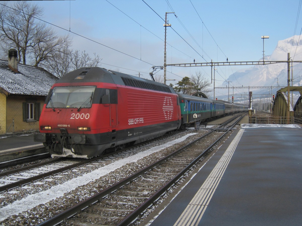 Aus dem Archiv: Re 460 089-6 mit einem IR aus Zrich bei Einfahrt in Landquart, 26.12.2010. Diese Lok trgt mittlerweile den  2000  Schriftzug nicht mehr, der IR den sie zieht wurde durch neue Regio Dostos ersetzt, und das Gebude links im Hintergrund wurde abgerissen...