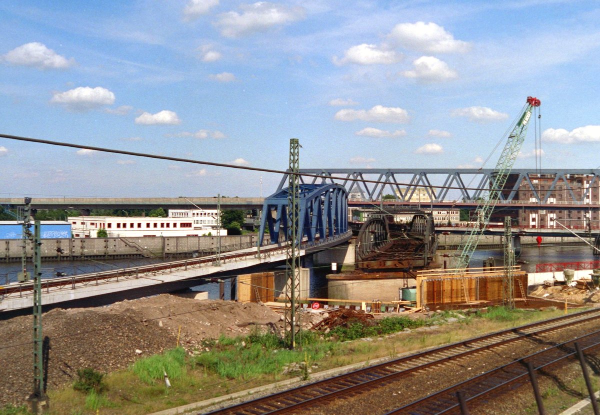 Aus dem Fenster eines über die  Pfeilerbahn  fahrenden Stadtexpress fällt der Blick am 26.06.1998 auf die Ostseite des ehemaligen Hamburger Hauptgüterbahnhofs: In der Bildmitte die eingleisige neue Brücke über den Billhafen von Abzw Ericus nach Rothenburgsort über den Billhafen, rechts die zweigleisige alte und teilweise bereits abgerissene Brücke, im Hintergrund quer verlaufend die Brücke der S-Bahn-Linien 3/31 von Neugraben nach Pinneberg/Altona, unten rechts die Güterzuggleise von Harburg zum Hauptbahnhof.