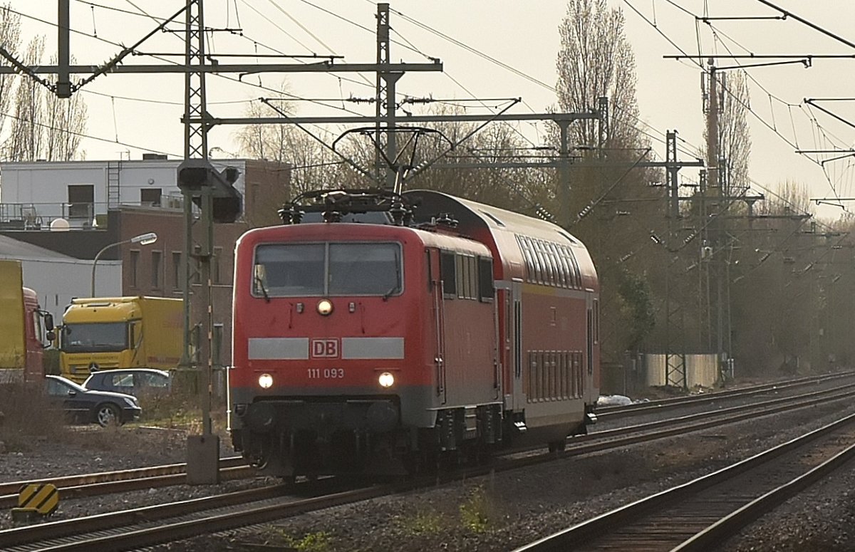 Aus dem Gegenlicht kommt die 111 093 mit einem Dostock als PbZ gen Neuss fahrend in Korschenbroich. 14.3.2017