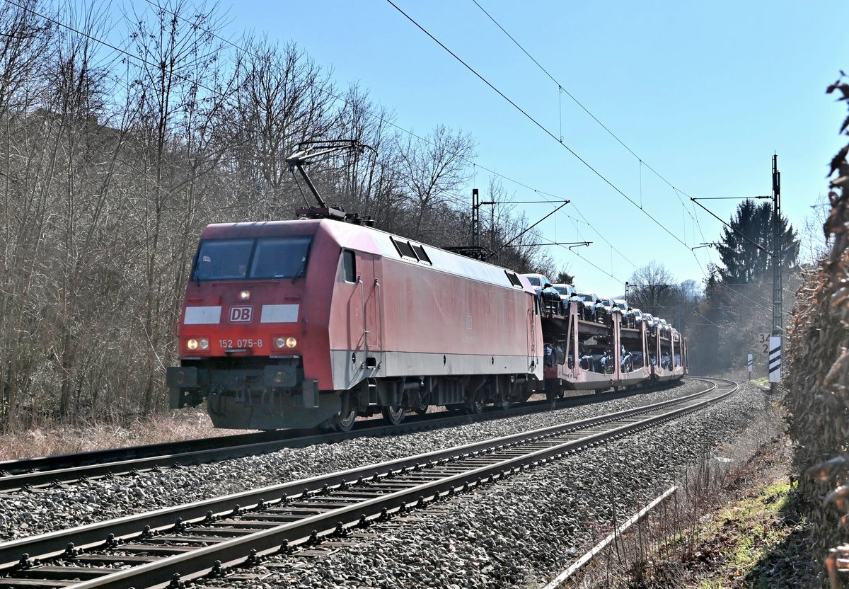 Aus dem Gegenlicht kommt die 152 075-8 mit dem Audizug am Mittag des 1.3.2021 durch Neckargerach gen Heidelberg.