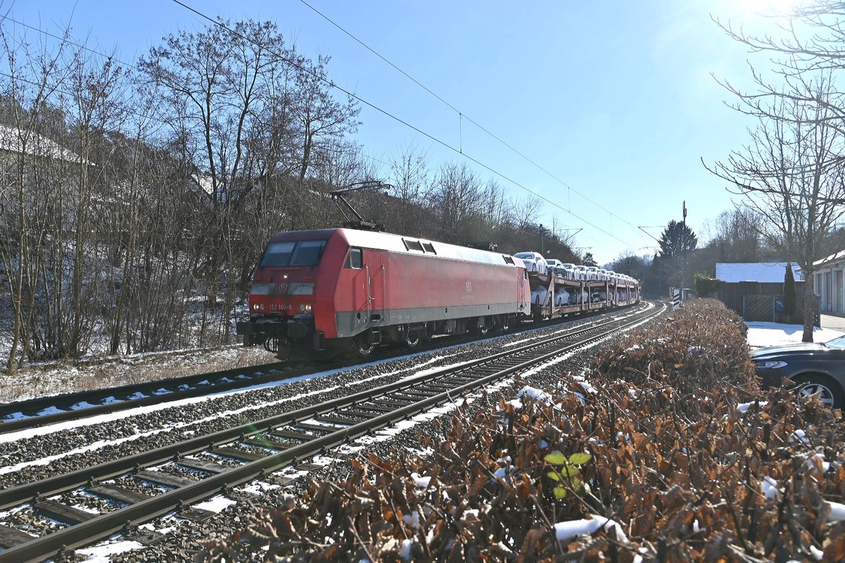 Aus dem Gegenlicht der Mittagssonne kommt 152 160-8 mit dem Millionenzug bei kaltem doch schönen Winterwetter durch Neckargerach in Richtung Heidelberg fahrend am Freitag den 12.2.2021